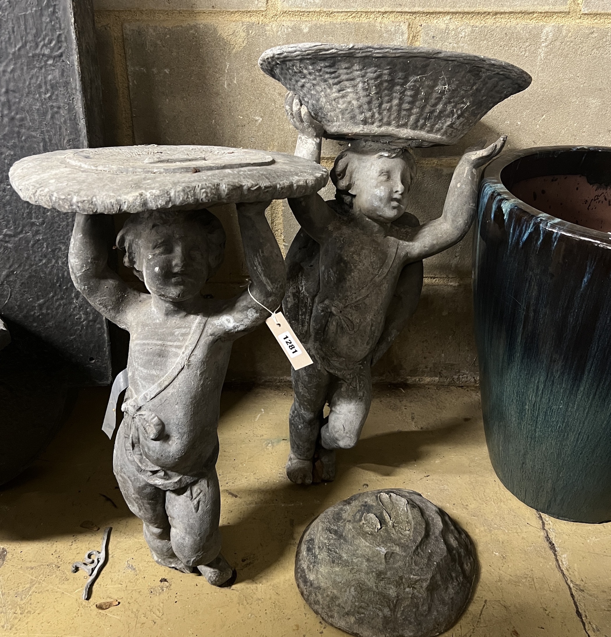 Two Victorian lead garden putto figures, one as a sundial, the other a birdbath, in need of restoration, larger height 69cm